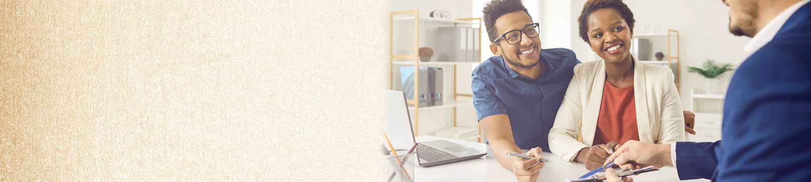 A man and a woman sitting at a desk talking to another businessman. 