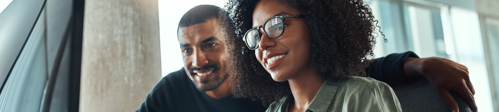 Man and woman appear to be working with one another on a computer.