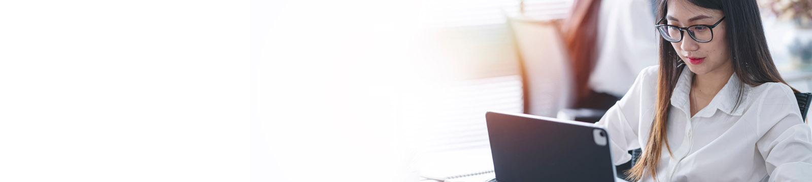 A woman is sitting at a table working on a computer. 